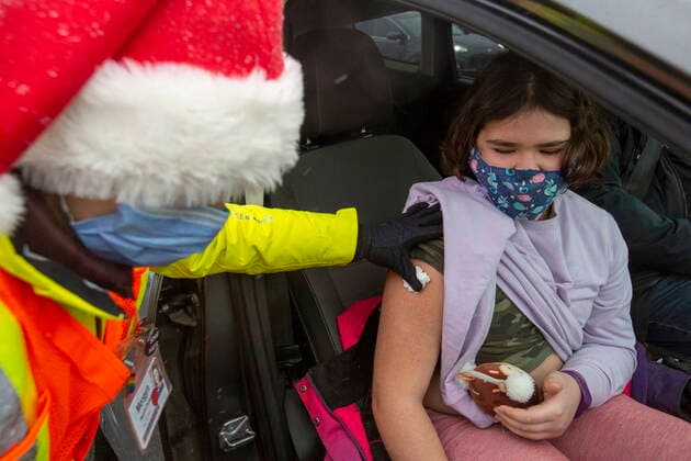 December 4, 2021, Kingston, Ontario, Canada: Medical student Morgyn McKerlie holds a cottton ball after giving Winnifred Davey, 10, a vaccine during a drive-thru COVID-19 vaccine clinic at St Lawrence College in Kingston, Ont., Saturday, Dec. 4, 2021. Kingston Canada - ZUMAc35_ 20211204_zaf_c35_005 Copyright: xLarsxHagbergx