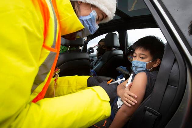December 4, 2021, Kingston, Ontario, Canada: Medical student Morgyn McKerlie gives Jarred Omamalin, 10, his vaccine during a drive-thru COVID-19 vaccine clinic at St Lawrence College in Kingston, Ont., Saturday, Dec. 4, 2021. Kingston Canada - ZUMAc35_ 20211204_zaf_c35_014 Copyright: xLarsxHagbergx