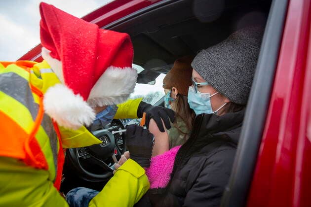 December 4, 2021, Kingston, Ontario, Canada: Medical student Morgyn McKerlie gives Korie Smith, 8, her vaccine as she sits in the lap of her mom, Kelita Smith, during a drive-thru COVID-19 vaccine clinic at St Lawrence College in Kingston, Ont., Saturday, Dec. 4, 2021. Kingston Canada - ZUMAc35_ 20211204_zaf_c35_011 Copyright: xLarsxHagbergx