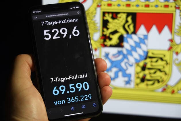 Coronavirus in Germany Covid 19 Dashboard of the Robert Koch Institute DEU, Germany, Bavaria 05 12 2021 The 7-day incidence for the state Cases last 7 days 100 000 PE is displayed on an iPhone, with the state coat of arms in the background.