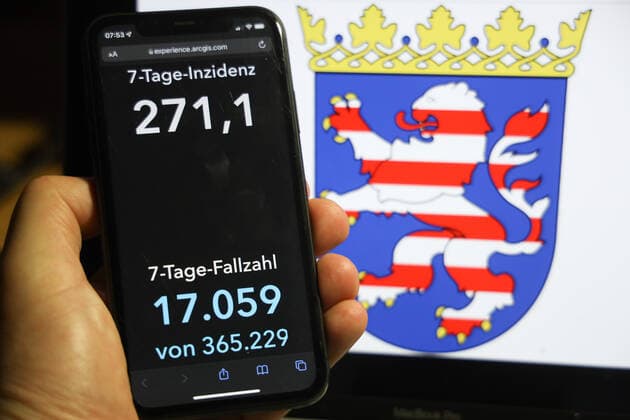 Coronavirus in Germany Covid 19 Dashboard of the Robert Koch Institute DEU, Germany, Hesse 05 12 2021 The 7-day incidence for the state Cases last 7 days 100 000 PE is displayed on an iPhone, with the state coat of arms in the background.