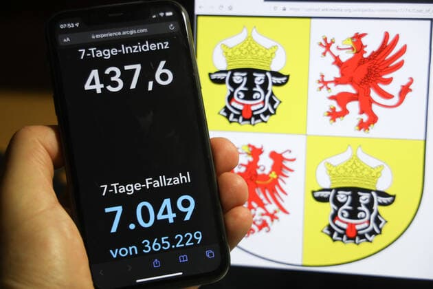 Coronavirus in Germany Covid 19 Dashboard of the Robert Koch Institute DEU, Germany, Mecklenburg Vorpommern 05 12 2021 The 7-day incidence for the state Cases last 7 days 100 000 P.E. is displayed on an iPhone, with the state coat of arms in the background.