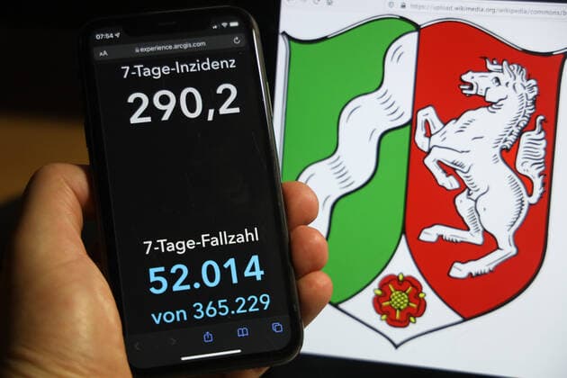 Coronavirus in Germany Covid 19 Dashboard of the Robert Koch Institute DEU, Germany, North Rhine Westphalia 05 12 2021 The 7-day incidence for the state Cases last 7 days 100 000 PE is displayed on an iPhone, with the state coat of arms in the background.