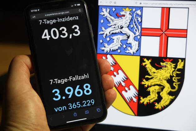 Coronavirus in Germany Covid 19 Dashboard of the Robert Koch Institute DEU, Germany, Saarland 05 12 2021 The 7-day incidence for the state Cases last 7 days 100 000 PE is displayed on an iPhone, with the state coat of arms in the background.