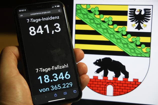 Coronavirus in Germany Covid 19 Dashboard of the Robert Koch Institute DEU, Germany, Saxony Anhalt 05 12 2021 The 7-day incidence for the state Cases last 7 days 100 000 PE is displayed on an iPhone, with the state coat of arms in the background.