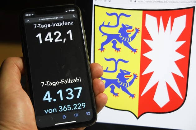 Coronavirus in Germany Covid 19 Dashboard of the Robert Koch Institute DEU, Germany, Schleswig Holstein 05 12 2021 The 7-day incidence for the state Cases last 7 days 100 000 p.e. is displayed on an iPhone, with the state coat of arms in the background.
