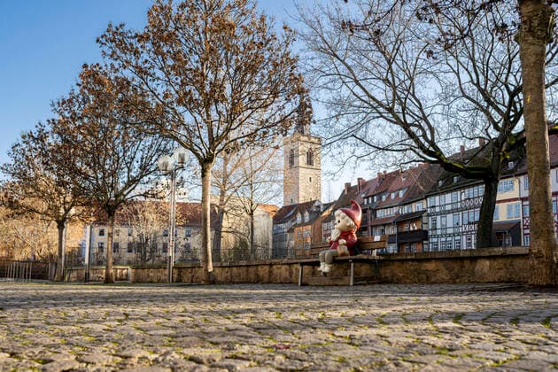SANDMANN FIGURE KRÄMERBRÜCKE ERFURT 05 12 2021 Erfurt The Sandmann figure sits on a bench behind the Erfurt Krämerbrücke on 5 December 2021