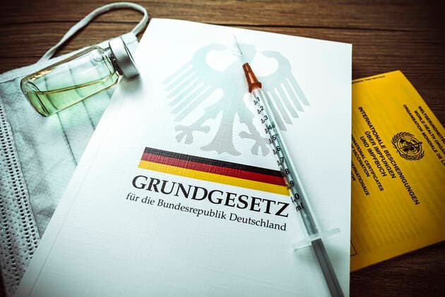 Vaccination syringe on the German Basic Law and vaccination certificate ** NUR FUER REDAKTIONELLE ZWECKE ** EDITORIAL USE ONLY **