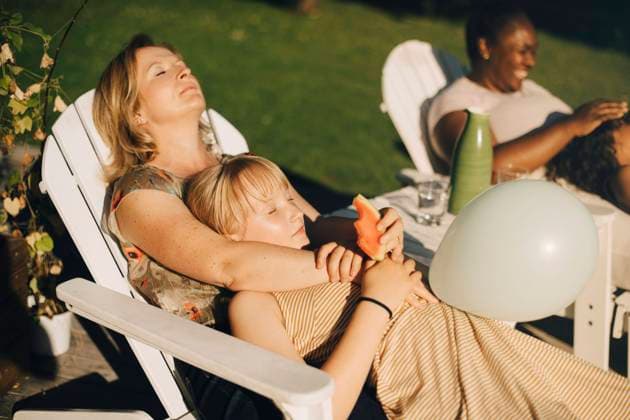 IMAGO Creative: Welttag für psychische Gesundheit am 10. Oktober Mother relaxing with daughter in backyard on deck chair during sunny day Sweden, Stockholm, model released Copyright: xMaskotx , MA90498