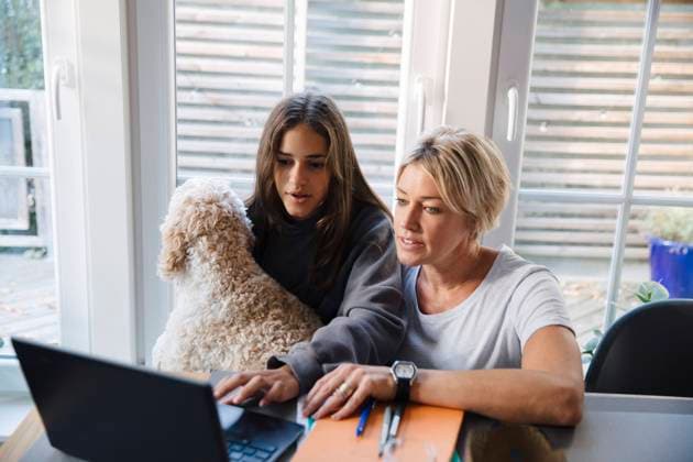 IMAGO Creative: Internationaler Frauenmonat, Gesundheit, Frauen in der Menopause IMAGO Creative: Internationaler Frauentag, Mental Load und Care-Arbeit Girl e-learning on laptop while sitting with mother and dog at home Sweden, Stockholm, model released, property released Copyright: xMaskotx , MA90542