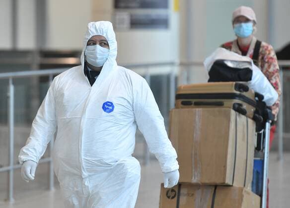 Russia South Africa Coronavirus 6714245 07.12.2021 An airport employee in protective gear escorts a passenger arrived from South Africa for further transfer to an observation facility in Sergiev Posad, amid the coronavirus disease outbreak with the emergence of the Omicron variant, at the Domodedovo International Airport named after Mikhail Lomonosov outside Moscow, Russia. Russian health authorities on December 6, said they have confirmed the first two cases of the omicron variant of coronavirus in travelers who returned from South Africa. Mikhail Voskresenskiy Sputnik Moscow region Russia  Copyright: xMikhailxVoskresenskiyx