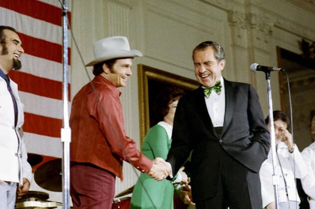 President Nixon shaking hands with country western singer Merle Haggard, and sharing a laugh onstage with the Osborne Brothers singers and The Strangers band after their Evening at White House East Room performance on St. Patrick s Day. March 17, 1973 1062_05_L_-11246-
