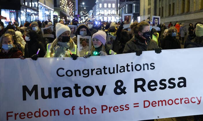 OSLO, NORWAY â€“ DECEMBER 10, 2021: People take part in a torchlight parade in honour of the 2021 Nobel Peace Prize winners from Oslo Central Station to the Grand Hotel where the laureates greet the procession participants from the balcony. The Norwegian Nobel Committee has decided to award the Nobel Peace Prize for 2021 to Filipino-American journalist, co-founder and CEO of Rappler Maria Ressa and Russian journalist, Novaya Gazeta editor-in-chief Dmitry Muratov in recognition of their efforts to safeguard freedom of expression, which is a precondition for democracy and lasting peace . Sergei Bobylev TASS  TS11B65A
