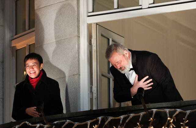 OSLO, NORWAY â€“ DECEMBER 10, 2021: Nobel Peace Prize winners, Filipino-American journalist, co-founder and CEO of Rappler Maria Ressa (L) Russian journalist, Novaya Gazeta editor-in-chief Dmitry Muratov greet the participants in a torchlight parade in honour of the 2021 Nobel Peace Prize winners from a balcony of the Grand Hotel. The Norwegian Nobel Committee has decided to award the Nobel Peace Prize for 2021 to Filipino-American journalist, co-founder and CEO of Rappler Maria Ressa and Russian journalist, Novaya Gazeta editor-in-chief Dmitry Muratov in recognition of their efforts to safeguard freedom of expression, which is a precondition for democracy and lasting peace . Sergei Bobylev TASS  TS11B678