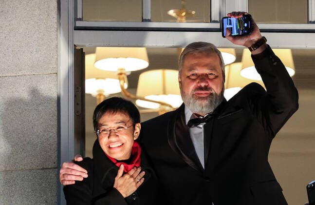 OSLO, NORWAY â€“ DECEMBER 10, 2021: Nobel Peace Prize winners, Filipino-American journalist, co-founder and CEO of Rappler Maria Ressa (L) and Russian journalist, Novaya Gazeta editor-in-chief Dmitry Muratov greet the participants in a torchlight parade in honour of the 2021 Nobel Peace Prize winners from a balcony of the Grand Hotel. The Norwegian Nobel Committee has decided to award the Nobel Peace Prize for 2021 to Filipino-American journalist, co-founder and CEO of Rappler Maria Ressa and Russian journalist, Novaya Gazeta editor-in-chief Dmitry Muratov in recognition of their efforts to safeguard freedom of expression, which is a precondition for democracy and lasting peace . Sergei Bobylev TASS  TS11B68F