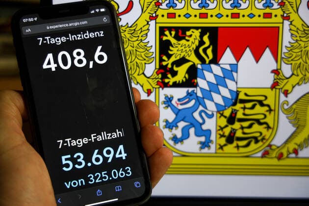 Coronavirus in Germany Covid 19 Dashboard of the Robert Koch Institute DEU, Germany, Bavaria 12 12 2021 The 7-day incidence for the state Cases last 7 days 100 000 PE is displayed on an iPhone, with the state coat of arms in the background.