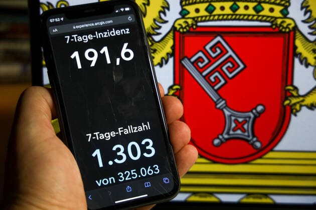 Coronavirus in Germany Covid 19 Dashboard of the Robert Koch Institute DEU, Germany, Bremen 12 12 2021 The 7-day incidence for the state Cases last 7 days 100 000 PE is displayed on an iPhone, with the state coat of arms in the background.