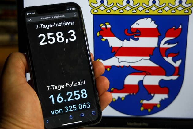 Coronavirus in Germany Covid 19 Dashboard of the Robert Koch Institute DEU, Germany, Hesse 12 12 2021 The 7-day incidence for the state Cases last 7 days 100 000 p.e. is displayed on an iPhone, with the state coat of arms in the background.