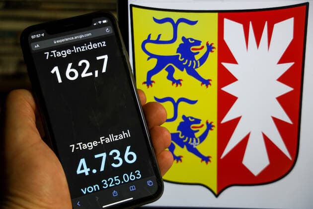 Coronavirus in Germany Covid 19 Dashboard of the Robert Koch Institute DEU, Germany, Schleswig Holstein 12 12 2021 The 7-day incidence for the state Cases last 7 days 100 000 PE is displayed on an iPhone, with the state coat of arms in the background.