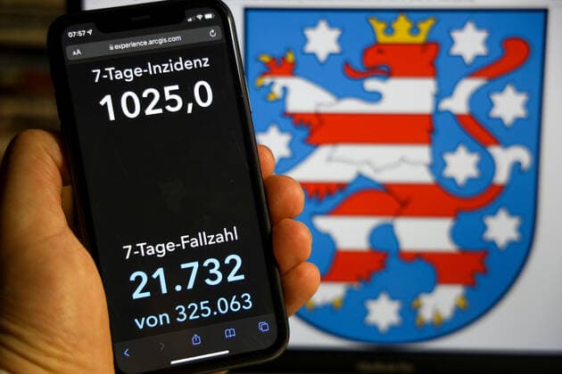 Coronavirus in Germany Covid 19 Dashboard of the Robert Koch Institute DEU, Germany, Thuringia 12 12 2021 The 7-day incidence for the state Cases last 7 days 100 000 PE is displayed on an iPhone, with the state coat of arms in the background.