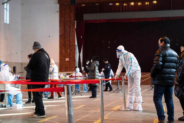 (211212) -- HARBIN, Dec. 12, 2021 -- Guan Chao works at a nucleic acid testing site in Harbin, capital of northeast China s Heilongjiang Province, Dec. 11, 2021. Clad in protective gear, Guan Chao started his volunteer work with his mother Wang Tao as usual. Guan, 27, is a dance teacher. Due to the latest resurgence of COVID-19 cases in Harbin, his offline teaching routine has been disrupted. Guan joined the fight against the epidemic. He became a volunteer for the citywide nucleic acid testing, medical supplies delivery and regular disinfection on public spaces. Seeing medical staff, community workers and volunteers work day and night, Guan s mother Wang Tao also joined the efforts. Wearing a red volunteer waistcoat and a face mas 