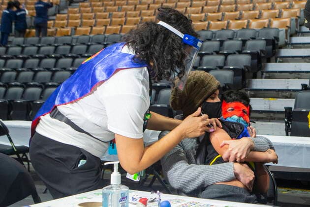 December 12, 2021, Toronto, ON, CANADA: Six-year-old Jaiden Kulkarni sits in the arms of his mother Neha as he receives his COVID-19 vaccine shot from his aunt Dr. Chetana Kulkarni from Sick Kids Hospital at a children s vaccine clinic held at the Scotiabank Arena, in Toronto, on Sunday, December 12, 2021. Toronto CANADA  - ZUMAc35_ 20211212_zaf_c35_014 Copyright: xChrisxYoungx