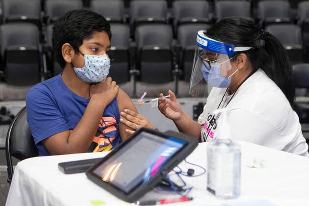 December 12, 2021, Toronto, ON, CANADA: Ten-year-old Rayyan Aziz Rafat receives his COVID-19 vaccine shot from Toronto Public Health s San Basak, at a children s vaccine clinic at the Scotiabank Arena, in Toronto, on Sunday, December 12, 2021. Toronto CANADA  - ZUMAc35_ 20211212_zaf_c35_015 Copyright: xChrisxYoungx