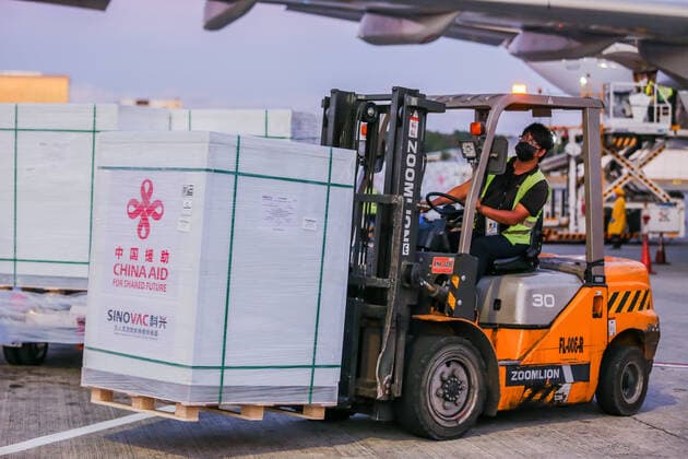 (211214) -- PASAY CITY, Dec. 14, 2021 -- A staff member transports cargos containing Sinovac vaccines donated by the Chinese government in Pasay City, the Philippines, Dec. 14, 2021. The Philippines received on Tuesday an additional batch of Sinovac vaccines donated by the Chinese government to help the Southeast Asian country recover quickly from the COVID-19 pandemic. ) PHILIPPINES-PASAY CITY-CHINA-DONATED SINOVAC COVID-19 VACCINES ROUELLExUMALI 