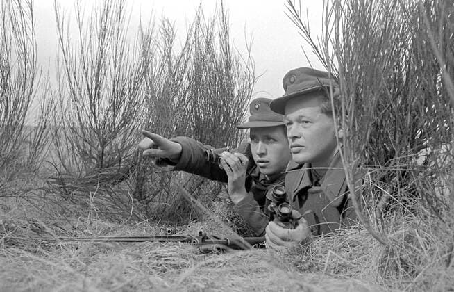 GDR Border Police is observing: Historical image The former GDR border police in operation at the inner-german border near Vacha. 1956. Historical image from GDR. German Democratic Republic. East Germany.