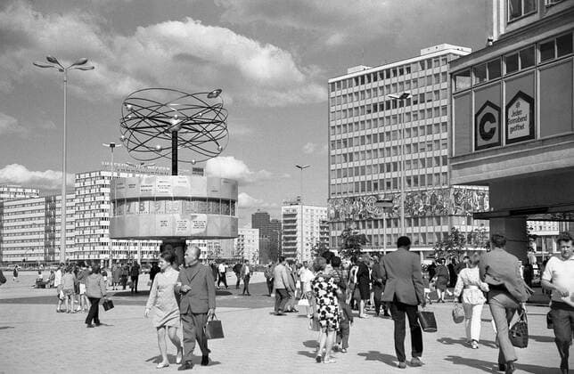 Urania Weltzeituhr Berlin - Worldtime Clock East Berlin Historisches Bild und Foto von der Urania Weltzeituhr auf dem Alexanderplatz in der Hauptstadt Berlin kurz nach der Aufstellung 1969. Die Uhrenanlage mit einer symbolischen Weltdarstellung im Berliner Ortsteil Mitte enthaelt auf ihrer metallenen Rotunde die Namen von 148 Staedten. Weltzeituhr ist Treffpunkt und Sehenswuerdigkeit für Berliner und Touristen in der deutschen Hauptstadt. Historical Image and Photography from the World Clock in East Berlin Alexanderplatz.
