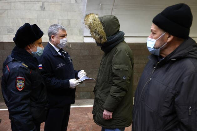 NOVOSIBIRSK, RUSSIA - DECEMBER 17, 2021: Andrei Benimetsky (2nd L), deputy head of the passenger transportation department of the Novosibirsk Region Transport and Road Infrastructure Ministry, and a police officer check face mask compliance at Ploshchad Lenina Station of the Novosibirsk Underground. Russia s Novosibirsk Region has been placed on a high alert amid a rise in COVID-19 cases, the face mask mandate applying to all public venues. Kirill Kukhmar TASS  TS11C199