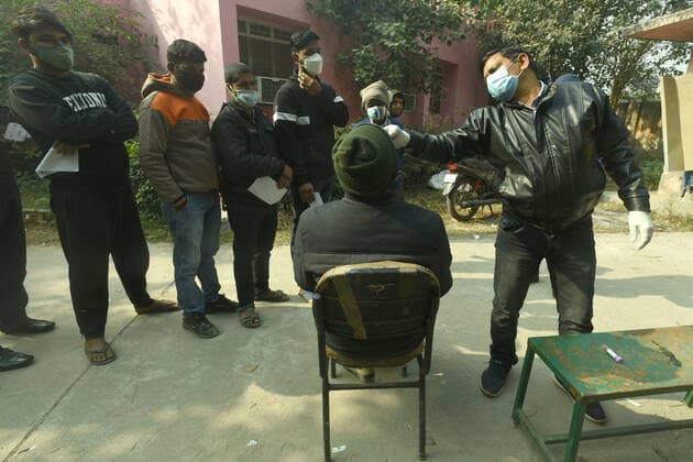 NOIDA, INDIA - DECEMBER 18: A health worker collects a swab sample for Covid-19 test, at Bhangel PHC in Sector 110, on December 18, 2021 in Noida, India. (Photo by Sunil Ghosh Hindustan Times ) Daily Life Amid Coronavirus Pandemic In India