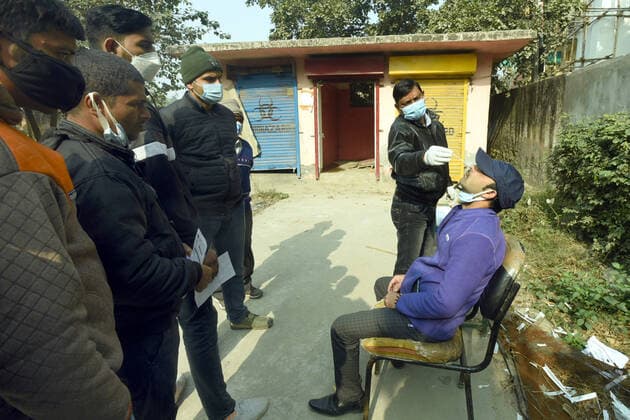 NOIDA, INDIA - DECEMBER 18: A health worker collects a swab sample for Covid-19 test, at Bhangel PHC in Sector 110, on December 18, 2021 in Noida, India. (Photo by Sunil Ghosh Hindustan Times ) Daily Life Amid Coronavirus Pandemic In India