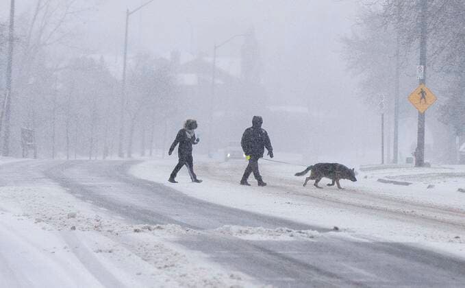 (211218) -- MISSISSAUGA (CANADA), Dec. 18, 2021 -- People cross a street during a snowy day in Mississauga, the Greater Toronto Area, Canada, on Dec. 18, 2021. A snowfall hit the Greater Toronto Area on Saturday. (Photo by Xinhua) CANADA-GREATER TORONTO AREA-MISSISSAUGA-SNOWFALL ZouxZheng 