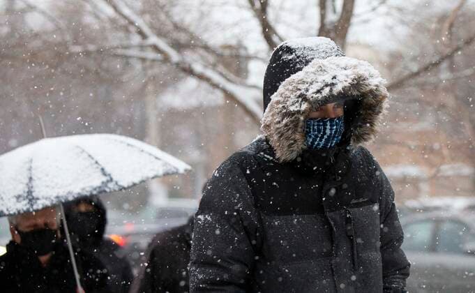 (211218) -- MISSISSAUGA (CANADA), Dec. 18, 2021 -- People wearing face masks are seen on a street during a snowy day in Mississauga, the Greater Toronto Area, Canada, on Dec. 18, 2021. A snowfall hit the Greater Toronto Area on Saturday. (Photo by Xinhua) CANADA-GREATER TORONTO AREA-MISSISSAUGA-SNOWFALL ZouxZheng 