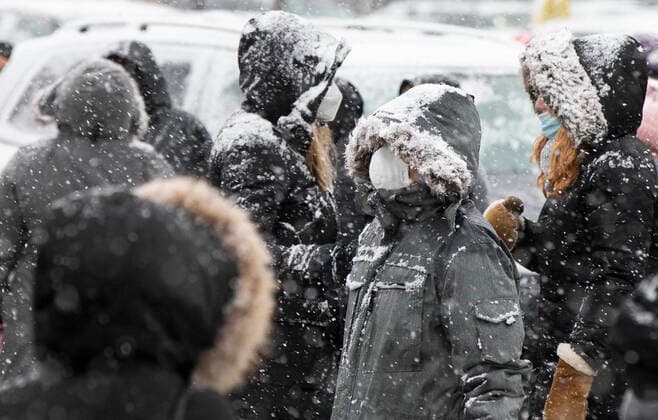 (211218) -- MISSISSAUGA (CANADA), Dec. 18, 2021 -- People wearing face masks line up to pick up free COVID-19 antigen rapid test kits during a snowy day in Mississauga, the Greater Toronto Area, Canada, on Dec. 18, 2021. A snowfall hit the Greater Toronto Area on Saturday. (Photo by Xinhua) CANADA-GREATER TORONTO AREA-MISSISSAUGA-SNOWFALL ZouxZheng 