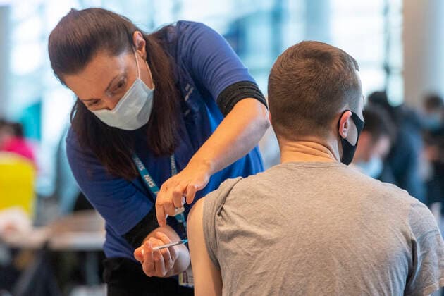 (211220) -- LONDON, Dec. 20, 2021 -- A man receives a vaccine jab at NHS (National Health Service) COVID Vaccine Center at Wembley Stadium in London, Britain, on Dec. 19, 2021. (Photo by Xinhua) UK-LONDON-COVID-19-VACCINATION CENTER RayxTang 