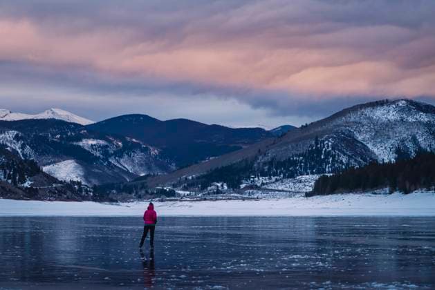 IMAGO Creative, Jahreszeit Winter, Eislaufen woman ice skating on frozen lake towards mountain range during sunset Basalt, Colorado, United States CR_BRHU211219-887462-01 ,model released, Symbolfoto