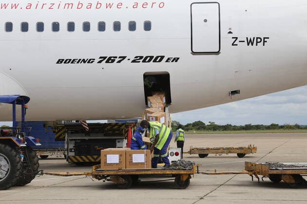 (211220) -- HARARE, Dec. 20, 2021 -- Workers unload medical supplies donated by China at Robert Gabriel Mugabe International Airport in Harare, Zimbabwe, on Dec. 20, 2021. Zimbabwe on Monday received a batch of Sinovac COVID-19 vaccine donated by China, which will boost the country s vaccination campaign as it battles the fourth wave of COVID-19 pandemic. ) ZIMBABWE-HARARE-CHINA-COVID-19 VACCINE-MEDICAL SUPPLIES-DONATION ZhangxYuliang 