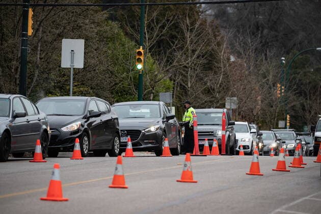 December 21, 2021, VANCOUVER, BC, CANADA: A Vancouver Police special constable directing traffic stands between motorists waiting in an hours-long lineup for a PCR test at a Vancouver Coastal Health COVID-19 drive-thru and walk-up testing site, in Vancouver, on Tuesday, December 21, 2021. VANCOUVER CANADA  - ZUMAc35_ 20211221_zaf_c35_025 Copyright: xDarrylxDyckx