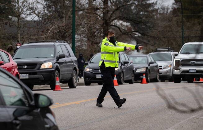 December 21, 2021, VANCOUVER, BC, CANADA: A Vancouver Police special constable directs traffic at a Vancouver Coastal Health COVID-19 drive-thru and walk-up testing site, in Vancouver, on Tuesday, December 21, 2021. VANCOUVER CANADA  - ZUMAc35_ 20211221_zaf_c35_030 Copyright: xDarrylxDyckx