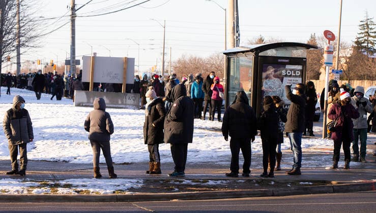 (211221) -- MISSISSAUGA (CANADA), Dec. 21, 2021 -- People wearing face masks line up to receive the COVID-19 vaccine outside a mobile vaccine clinic in Mississauga, Ontario, Canada, on Dec. 21, 2021. Canada reported 9,597 new COVID-19 cases Tuesday afternoon, bringing the cumulative total to 1,907,180 cases with 30,082 deaths, according to CTV. (Photo by Xinhua) CANADA-MISSISSAUGA-COVID-19-CASES-1.9 MLN ZouxZheng 