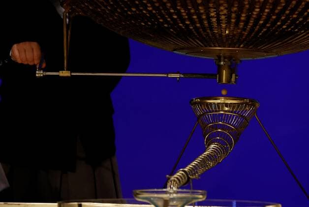 A wooden ball with a number falls from the lottery drum during El Gordo traditional Spanish Christmas Lottery draw held in the Royal Theater in Madrid, Spain, 22 December 2021. The traditional Spanish Christmas Lottery El Gordo (The Fat One) will share out a total of 2.38 billion euros that will be divided in 15,304 prizes. The main prizes per ticket are, 400,000 euros for the first prize; 125,000 for the second; 50,000 for the third; 20,000 for the fourth; and 6,000 for the fifth. The big drum contains a total of 100,000 wooden balls with the lottery numbers, where the small one contains a total of 1,807 wooden balls with the prizes quantities. El Gordo traditional Spanish Christmas Lottery draw !ACHTUNG: NUR REDAKTIONELLE NUTZUNG!  Copyright: xJUANxCARLOSxHIDALGOx GRAF1094 20211222-fd20af4d65e106e1bbc0090107e89f7aa9dc08e1