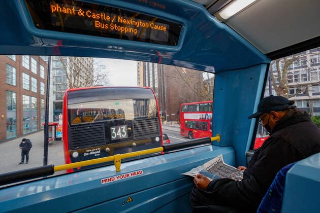 A man wears a face protective surgical mask as they read the press sitting on the 2nd deck of a bus towards Shoreditch in central London on Wednesday, Dec 22, 2021. Official figures show that confirmed cases announced on Tuesday and on the previous five days for the capital have been between 20,491 and 26,608, with the three most recent days lower than the first three. Tuesday was the lowest at 20,491. (VX Photo Vudi Xhymshiti), Omicron Outbreak London Central England United Kingdom  , Copyright: xVudixXhymshitix