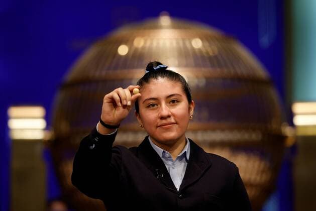 Bilder des Jahres 2021, News 12 Dezember News Themen der Woche KW51 A student from San Ildefonso school calls out number 86148 winner of the first prize during El Gordo traditional Spanish Christmas Lottery draw held in the Royal Theater in Madrid, Spain, 22 December 2021. The traditional Spanish Christmas Lottery El Gordo (The Fat One) will share out a total of 2.38 billion euros that will be divided in 15,304 prizes. The main prizes per ticket are, 400,000 euros for the first prize; 125,000 for the second; 50,000 for the third; 20,000 for the fourth; and 6,000 for the fifth. The big drum contains a total of 100,000 wooden balls with the lottery numbers, where the small one contains a total of 1,807 wooden balls with the prizes quantities. El Gordo traditional Spanish Christmas Lottery draw !ACHTUNG: N  Copyright: xJUANxCARLOSxHIDALGOx GRAF1238 20211222-35e85abd9c013e8bfe87483a977a1131bc2182a8