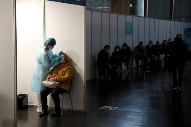 (211223) -- LISBON, Dec. 23, 2021 -- A health worker takes a swab sample from a woman at a COVID-19 testing center in Cascais, Portugal, Dec. 22, 2021. (Photo by Xinhua) PORTUGAL-CASCAIS-COVID-19-TESTING PedroxFiuza 