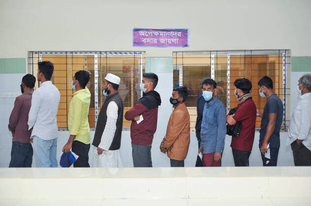 December 23, 2021: Sylhet, Bangladesh: Vaccine aspirants qued to receive a Pfizer vaccine against Covid-19 disease at the M A G Osmani medical college & hospital vaccination center in Sylhet. Meanwhile, in Dhaka city of Bangladesh launched the COVID-19 booster shot campaign with Pfizer vaccine to scale up its efforts for containing the spread of the lethal virus. - ZUMAr143 20211223_zap_r143_001 Copyright: xMdxRafayatxHaquexKhanx