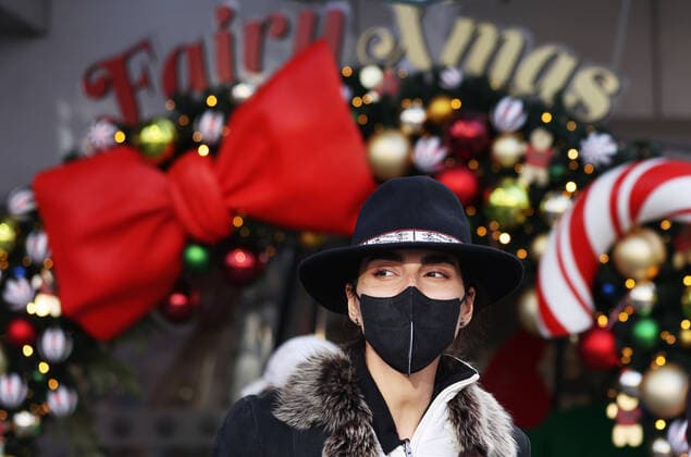 News Bilder des Tages Coronavirus, Eindrücke aus Paris (211224) -- PARIS, Dec. 24, 2021 -- A woman wearing a face mask walks on the Champs Elysees Avenue in Paris, France, Dec. 23, 2021. ) FRANCE-PARIS-COVID-19-DAILY LIFE GaoxJing 