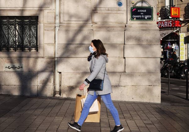 Coronavirus, Eindrücke aus Paris (211224) -- PARIS, Dec. 24, 2021 -- A woman carrying shopping bags walks on the Champs Elysees Avenue in Paris, France, Dec. 23, 2021. ) FRANCE-PARIS-COVID-19-DAILY LIFE GaoxJing 