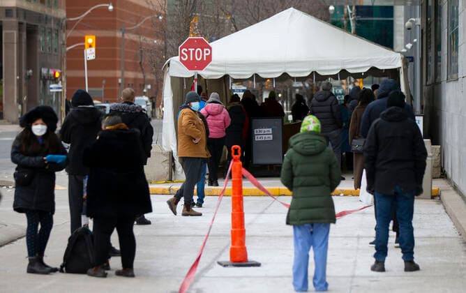 Coronavirus, Eindrücke aus Kanada (211224) -- TORONTO, Dec. 24, 2021 -- People wearing face masks line up to enter a COVID-19 assessment center in Toronto, Canada, on Dec. 23, 2021. Canada set a new daily record of 20,699 COVID-19 cases on Thursday, bringing the cumulative total number to 1,945,754 cases with 30,131 deaths, according to CTV. (Photo by Xinhua) CANADA-COVID-19-CASES-RECORD HIGH ZouxZheng 